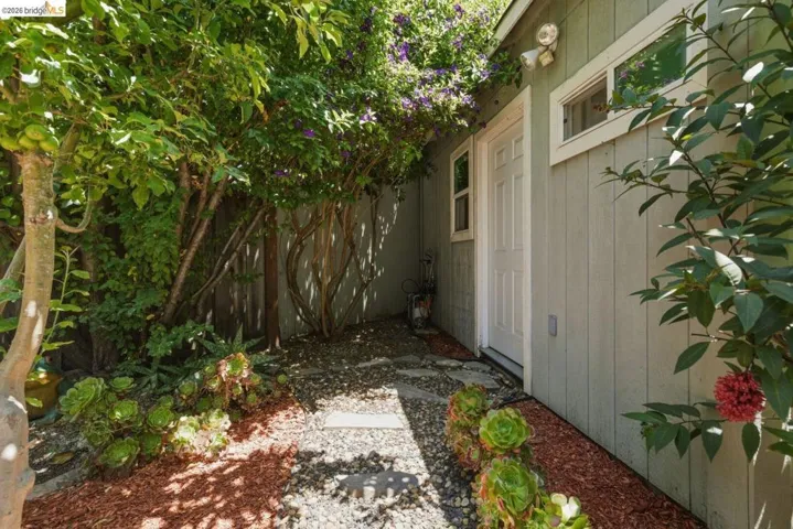Private exterior entry featuring a paneled door, multiple windows, and light gray vertical siding