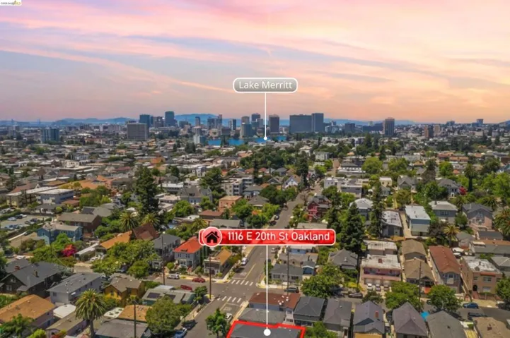 Aerial perspective showcasing a residential neighborhood with a distant cityscape and water body under a colorful sky