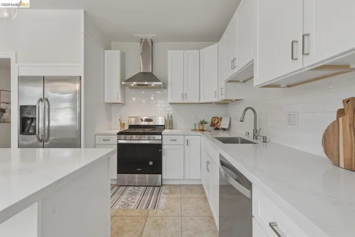 Modern kitchen featuring white shaker cabinetry and light-toned countertops