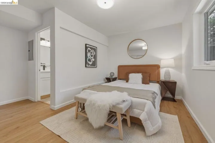 Bright interior space featuring wood-finish flooring, white walls, and a recessed window