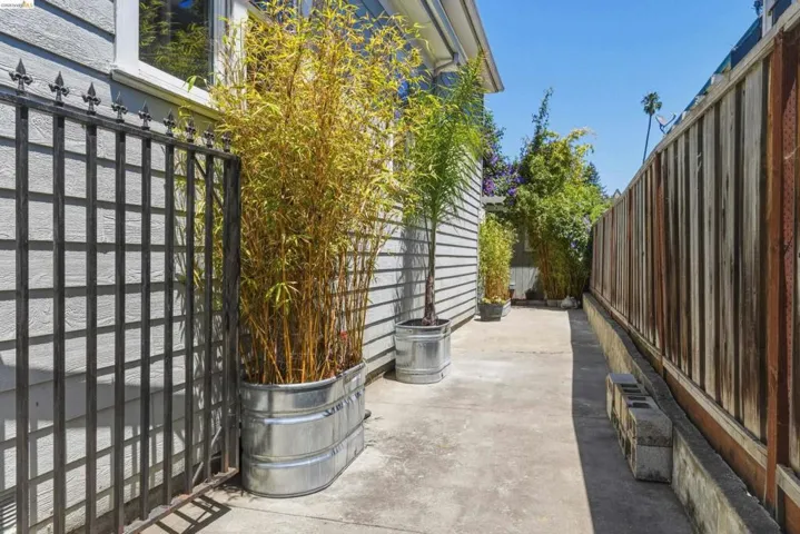 Side yard with concrete hardscaping, horizontal plank fencing, and horizontal siding
