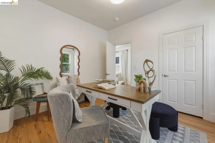 Bright interior space featuring wood-finish flooring, white walls, and a six-panel interior door