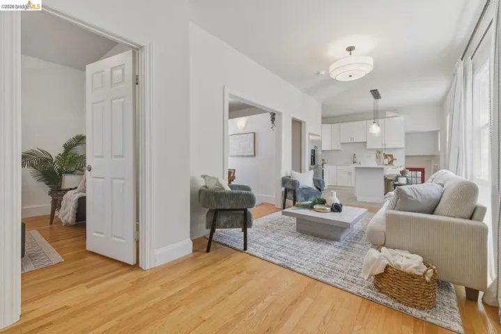 Living area featuring light wood-finish flooring, white baseboards, and a circular ceiling fixture