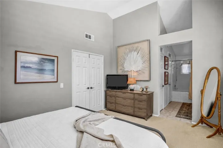 The view in the primary bedroom towards the door show off the high ceilings and natural light.