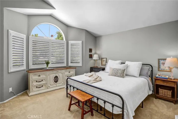 The primary bedroom is located upstairs and has a beautiful view of the green lush backyard.