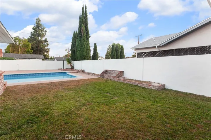 Out back, the pool takes center stage. Re-plastered in 2021 and complemented by a newer skimmer, it's ready for everything from summer gatherings to quiet afternoons spent poolside. The spacious pool deck, grassy lawn, and raised flowerbeds provide room to entertain, garden, play, or simply enjoy being outdoors.