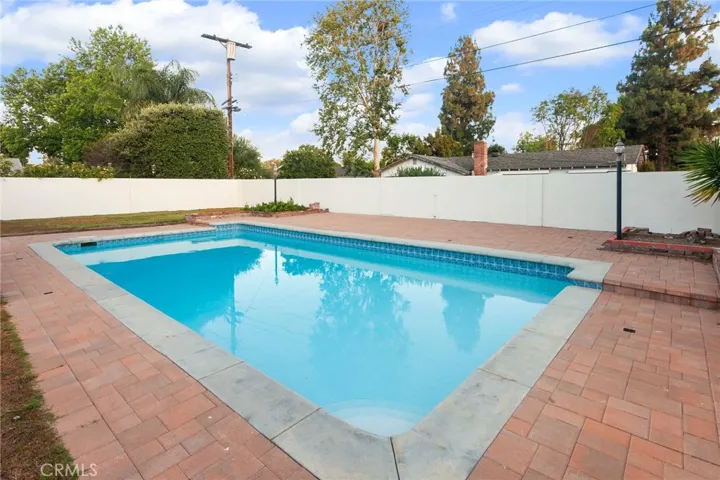 Out back, the pool takes center stage. Re-plastered in 2021 and complemented by a newer skimmer, it's ready for everything from summer gatherings to quiet afternoons spent poolside. The spacious pool deck, grassy lawn, and raised flowerbeds provide room to entertain, garden, play, or simply enjoy being outdoors.