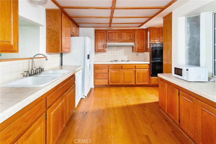 The kitchen offers abundant cabinetry and workspace, and the dining area serves as a natural gathering spot with easy access to both the backyard and bonus room.