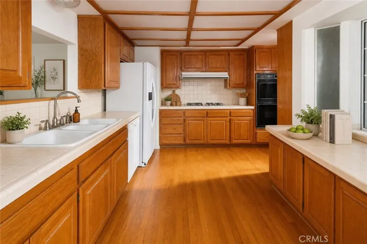 The kitchen offers abundant cabinetry and workspace, and the dining area serves as a natural gathering spot with easy access to both the backyard and bonus room.  Photo is virtually staged.