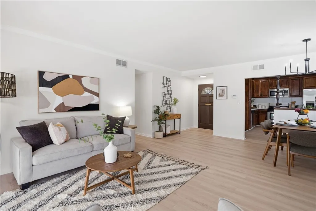 Step inside to an inviting open-concept living and dining area featuring luxury wide-plank vinyl-wood flooring, plantation shutters, and fresh interior paint