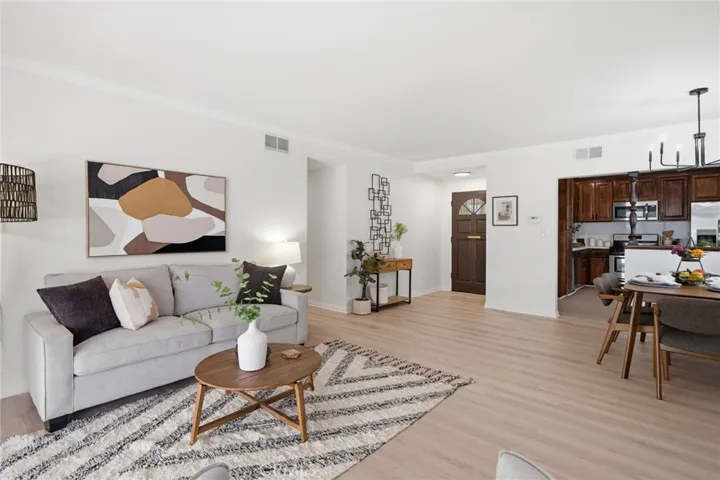 Step inside to an inviting open-concept living and dining area featuring luxury wide-plank vinyl-wood flooring, plantation shutters, and fresh interior paint