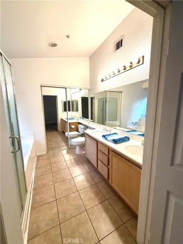 Primary Bath has two sinks, entry to walk in closet