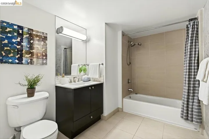 Bathroom featuring a dark wood-finish vanity with a light countertop, a rectangular mirror, and a wall-mounted light fixture