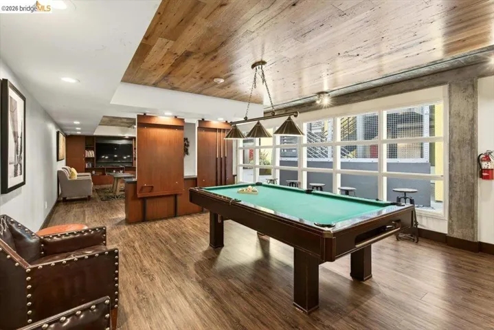 Recreational space featuring wood-finish flooring and a wood-panel ceiling accent