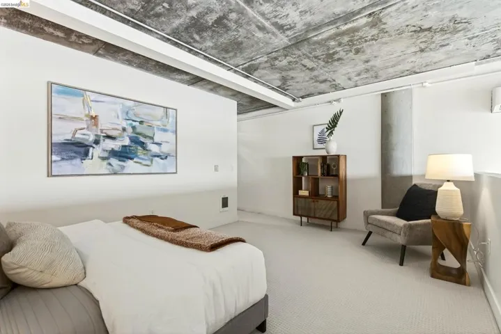Carpeted interior space featuring a textured concrete ceiling, white walls, and a recessed air conditioning unit