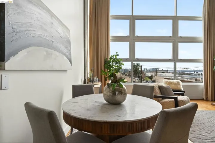 Dining area featuring a round table with a stone-finish top and a fluted wood base