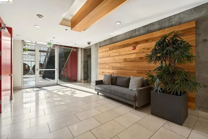 Entryway featuring light-toned rectangular tile flooring, a wooden accent wall, and a wood-paneled ceiling detail