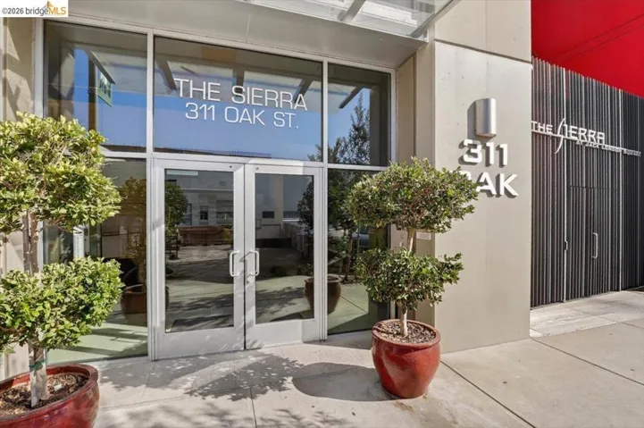 Building entrance featuring large glass doors, an overhead canopy, and exterior signage