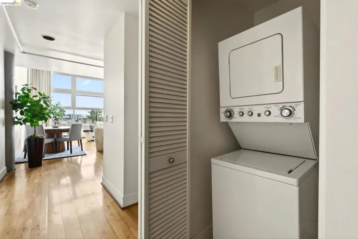 Integrated laundry closet featuring a stacked washer and dryer unit