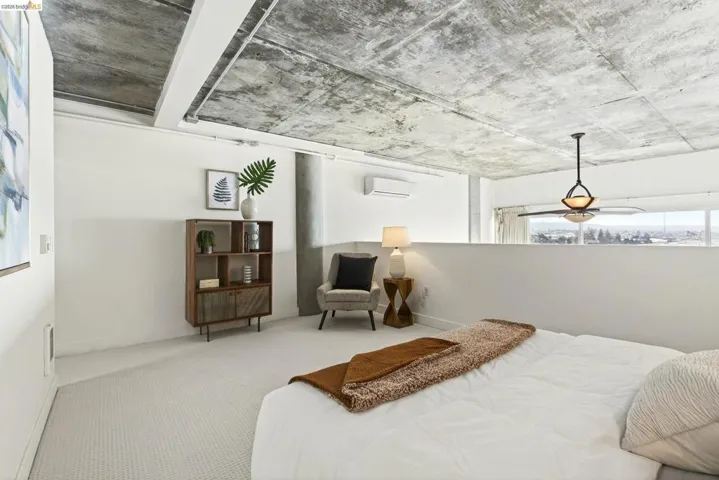 Open-concept room featuring a textured concrete ceiling, light-colored carpeting, and a half-height partition wall