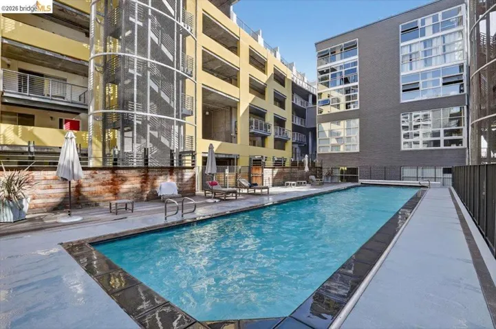 Outdoor swimming pool surrounded by a light-colored pool deck and dark tile coping
