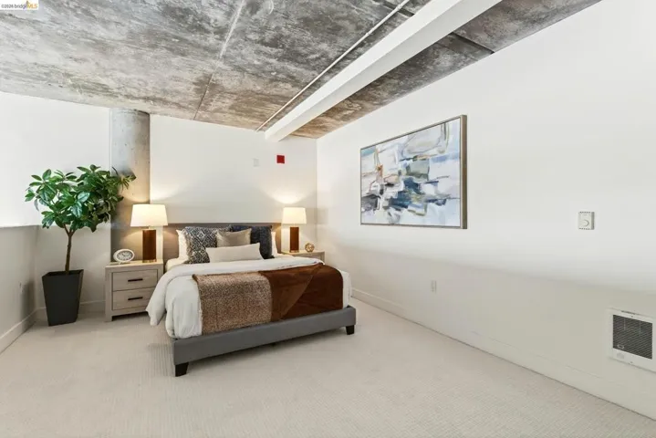 Exposed concrete ceiling and structural pillar complement white walls and light-toned carpeting