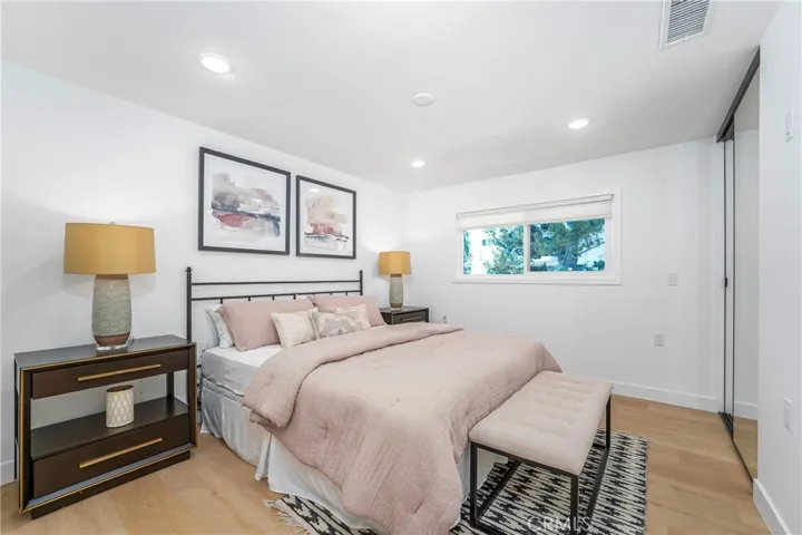 Primary suite with room for King size bed, dresser & nightstands, large closet with mirrored wardrobe doors, & flat panel TV wall,