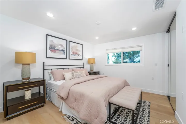 Primary suite with room for King size bed, dresser & nightstands, large closet with mirrored wardrobe doors, & flat panel TV wall,