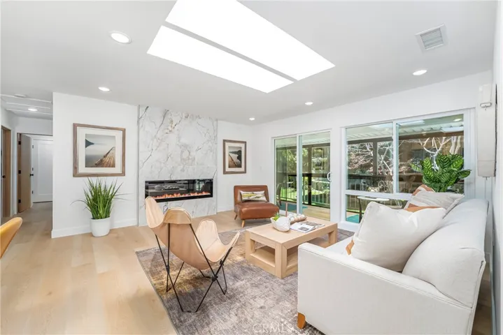 Luxurious and comfortable living room with recessed lighting, skylight, electric fireplace with TV outlet, large storage closet and wonderful patio overlooking the greenbelt