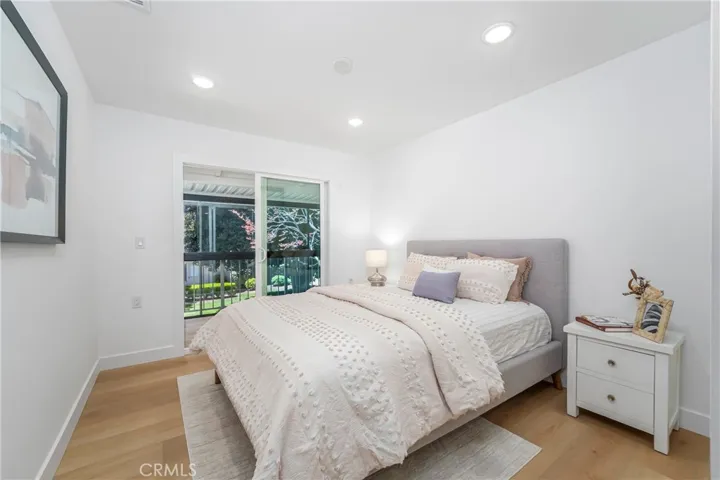 Guest bedroom with patio door, mirrored wardrobe doors, recessed lights, ceiling fan prewire