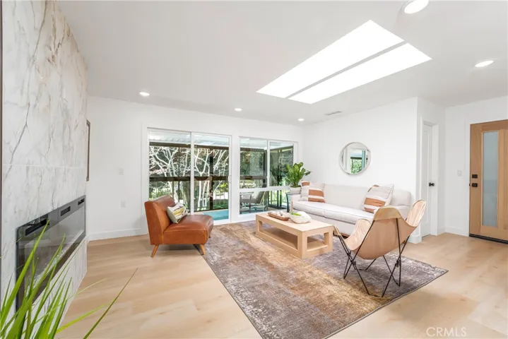 Luxurious and comfortable living room with recessed lighting, skylight, electric fireplace with TV outlet, large storage closet and wonderful patio overlooking the greenbelt