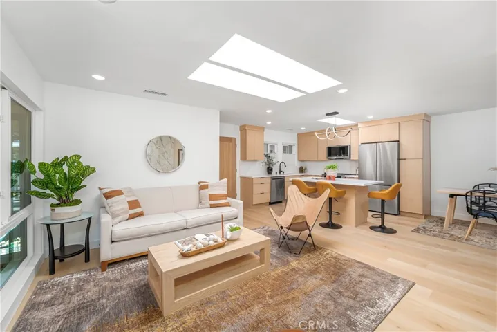 Luxurious and comfortable living room with recessed lighting, skylight, electric fireplace with TV outlet, large storage closet and wonderful patio overlooking the greenbelt