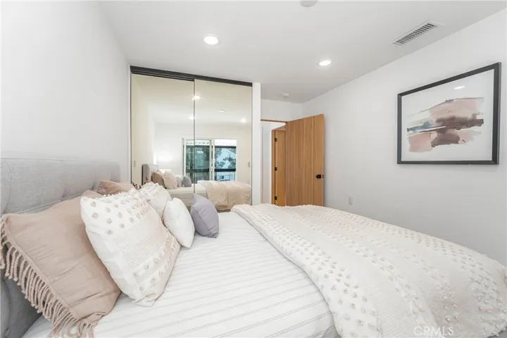Guest bedroom with patio door, mirrored wardrobe doors, recessed lights, ceiling fan prewire