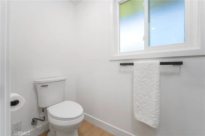 Primary bath with dual sink vanity, medicine cabinet, lighted mirror, pocket door to shower with bench & shower wand, plus separate showerhead & shampoo niche. Electrical receptacle for bidet.