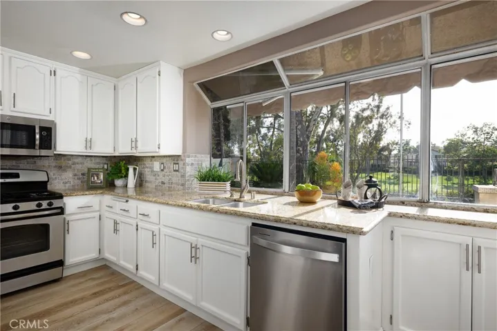 There are granite countertops and stainless steel appliances in the kitchen.