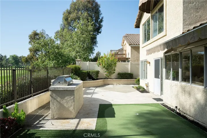 The backyard feature a built-in BBQ and lush landscaping.