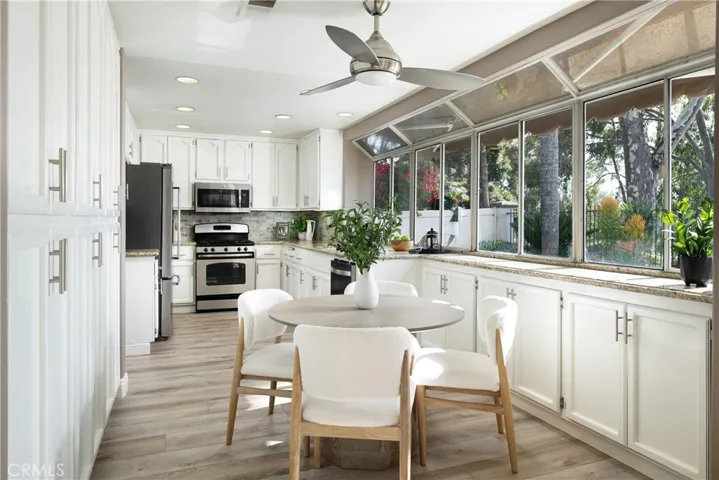 The kitchen features white cabinetry and a sunny breakfast nook.