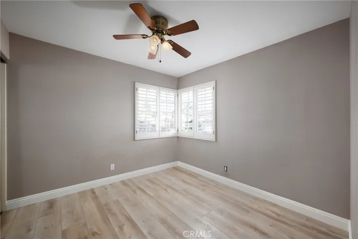 Additional guest bedroom located upstairs with a ceiling fan and plantation shutters.