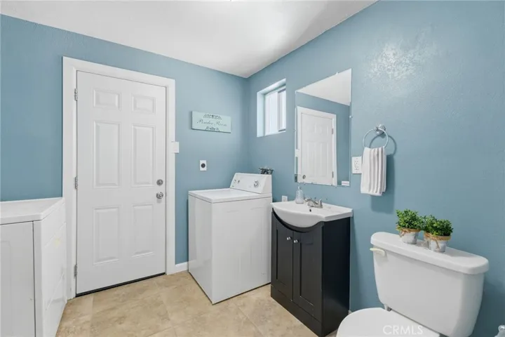1/2 Bath & Laundry room with door to backyard pool area