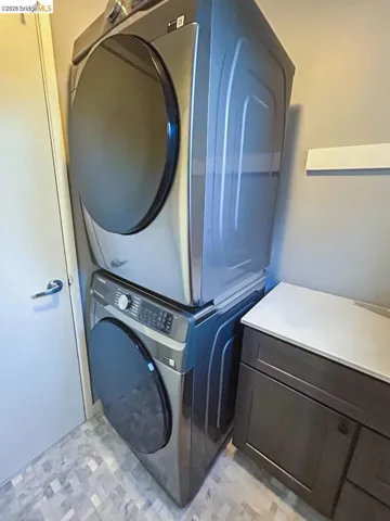 Stacked washer and dryer unit with a dark gray finish