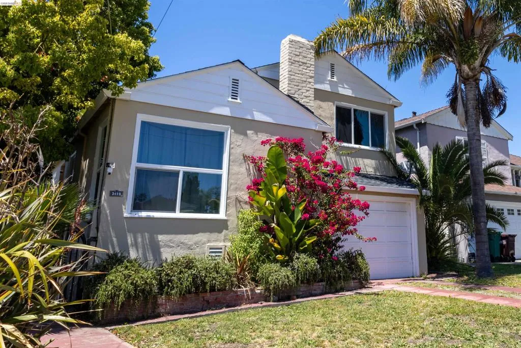 Two-story residence featuring a stucco exterior, white trim, and a prominent front-facing gable