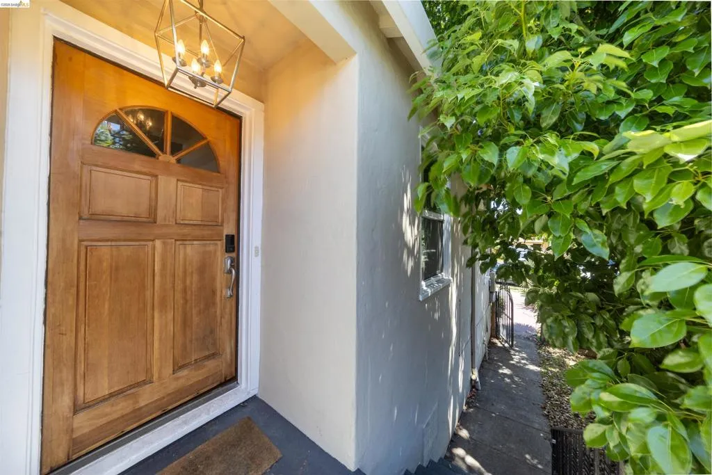 Solid wood entry door with a decorative arched transom and a contemporary geometric pendant light fixture