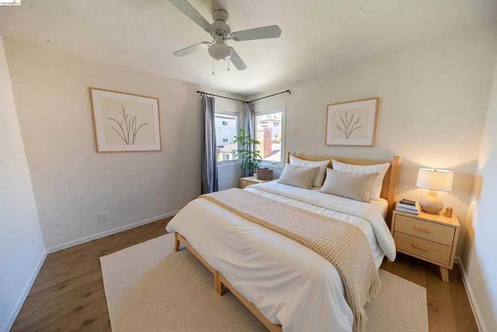 Bedroom featuring wood-finish flooring, a ceiling fan, and corner windows