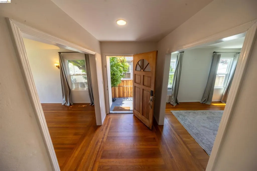 Entryway featuring wood-finish flooring, a recessed ceiling light, and a paneled entry door with an arched glass insert