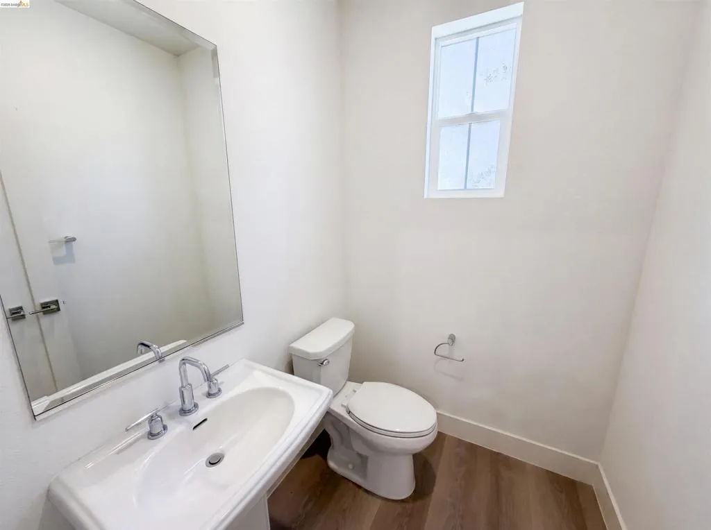 Pedestal sink with chrome fixtures and a rectangular mirror