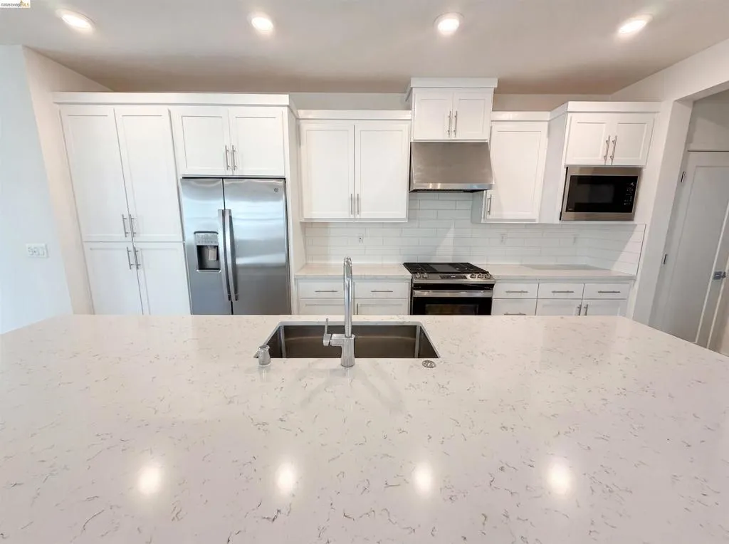 Expansive kitchen island featuring an undermount stainless steel sink
