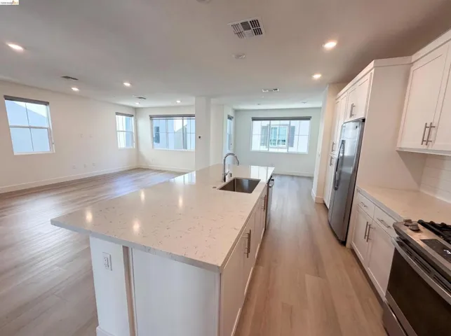 Modern kitchen island featuring a stainless steel sink and a light-toned countertop