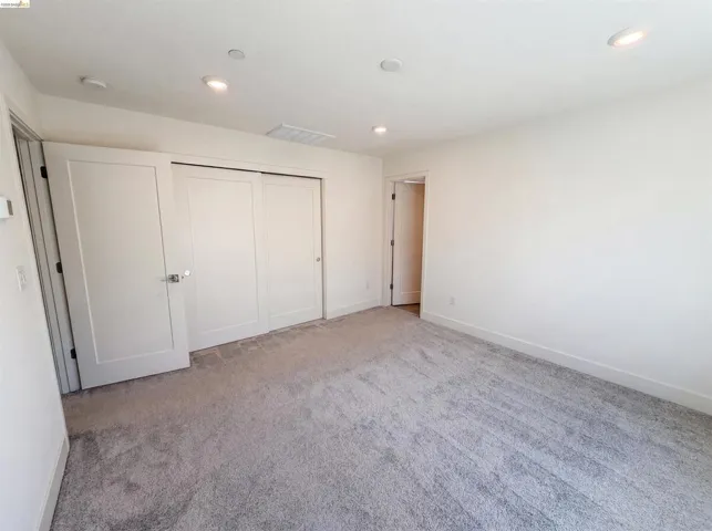 Light gray carpeting extending throughout, with white walls and trim