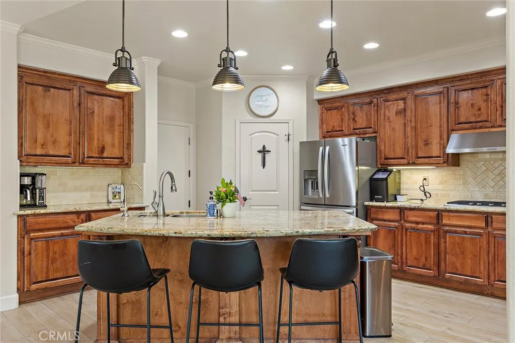 The kitchen features a breakfast bar, pantry, stainless steel appliances, granite countertops as well as pendant & recessed lighting.