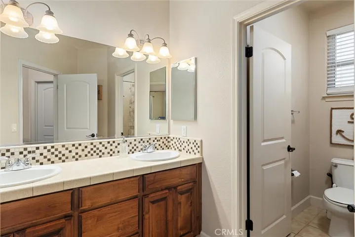 The guest bathroom upstairs has a separate double vanity area from the shower room.